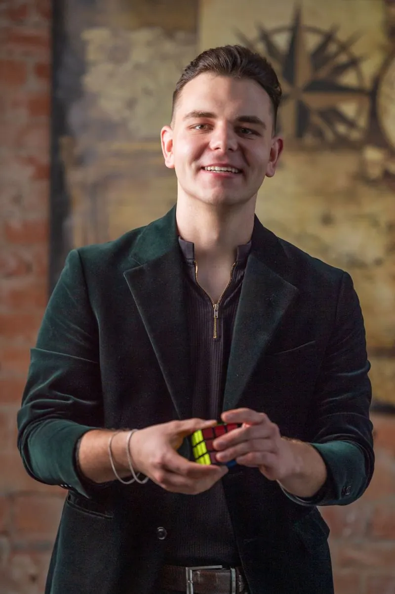 Ürögdi Ábel mosolyogva egy Rubik-kockát tart a kezében